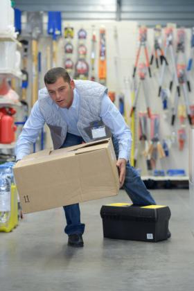 Man stumbling while carrying box.