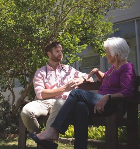 Senior woman talking with doctor outside.